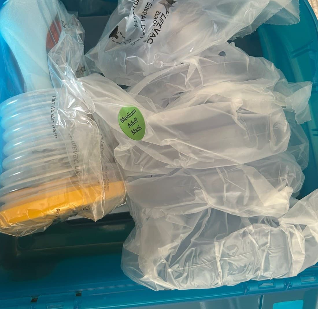 De koffer geopend, met het apparaat en de verzegelde maskers